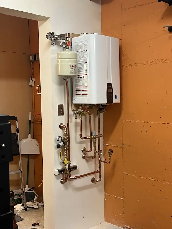 Plumbing technician inspecting water heater connections in Berkshire Lakes